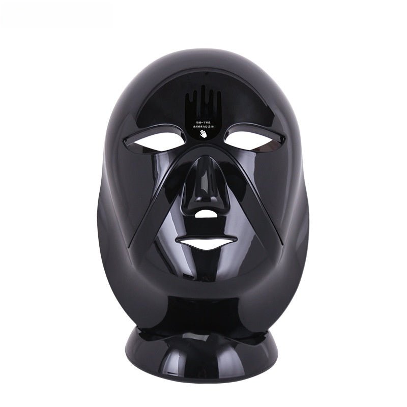 Glossy black LED phototherapy acne removal mask on a matching stand.