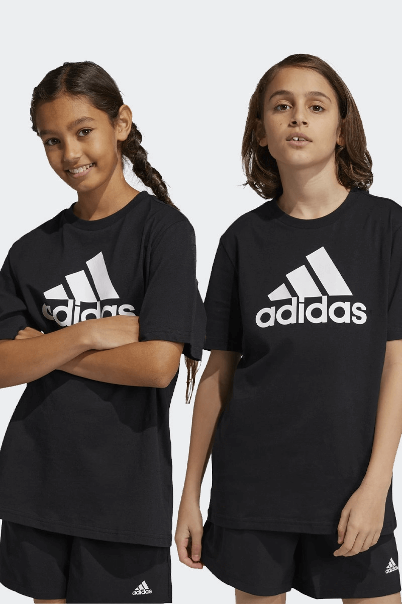 Two kids wearing black Adidas t-shirts from the Kids Essentials collection