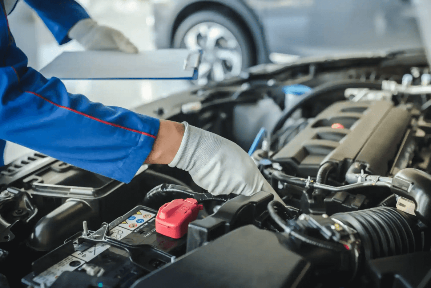 Mechanic inspecting engine, showcasing Car Essentials for efficient vehicle maintenance and performance.