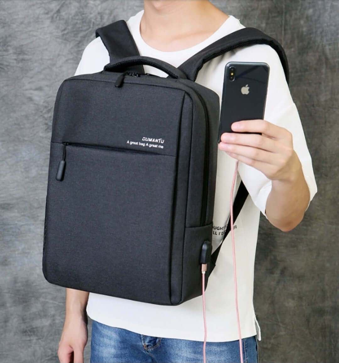 Man holding a phone with a black backpack, part of Laptops & Office Supplies Essentials collection.