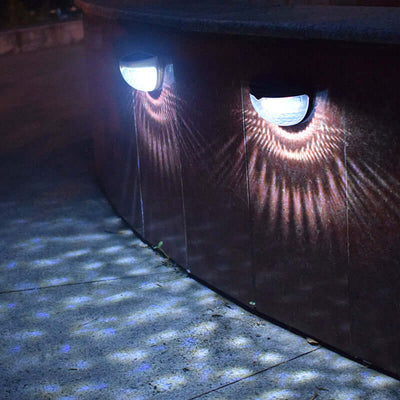 Solar powered outdoor waterproof garden lamp illuminating a curved wall with patterned light at night.