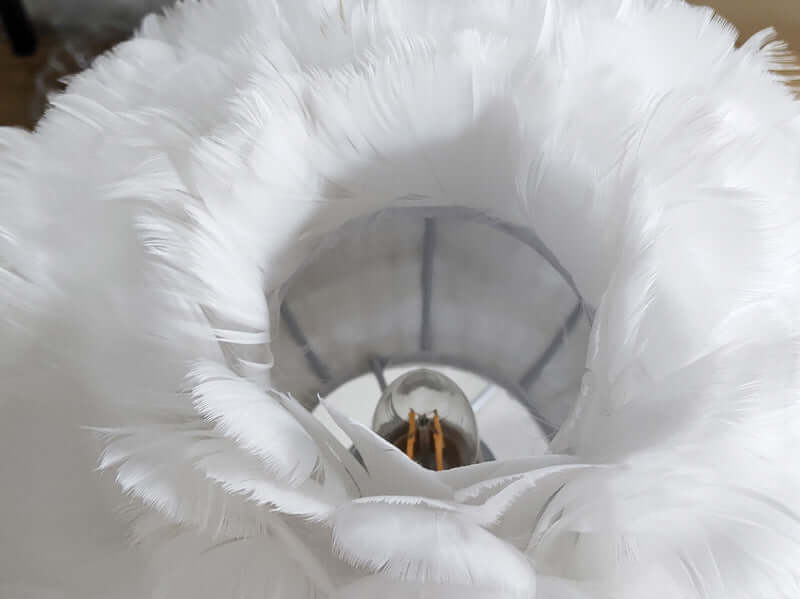 Close-up of Luxury Feather Table Lamp featuring natural white goose feather lampshade and modern design.