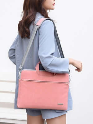 Woman carrying PU Leather Laptop Bag in pink for MacBook and notebooks, offering style & protection with waterproof material.