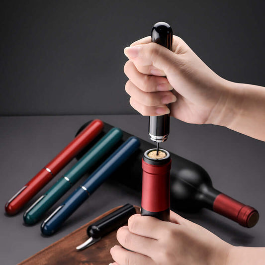 Person using Red Wine Bottle Opener, a pen-shaped air pressure corkscrew, to open a wine bottle with ease and efficiency.