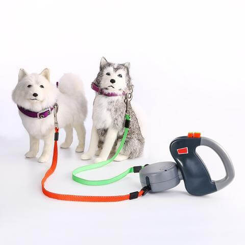 Retractable Dual Dog Leash with plush dog models, highlighting the tangle-free design and automatic retractable feature.