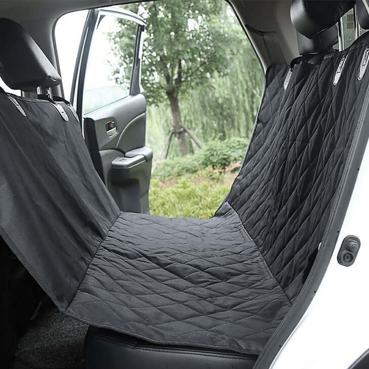 Waterproof Pet Car Seat Cushion installed in rear seat of a car, black quilted design, ideal for travel with pets.